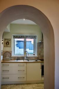 an archway in a kitchen with a sink and a window at Cartref, 1860s family home. in Bridgend