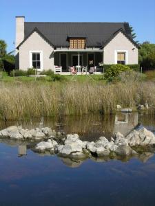 a house with a lake in front of it at Tranquility in Hermanus