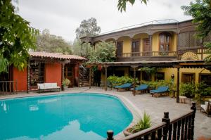 a swimming pool in front of a house at Hotel & Hacienda El Carmelo in Ica