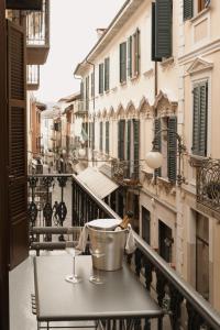 - une table sur un balcon avec vue sur la rue dans l'établissement Caffè delle Rose Les Chambres, à Verbania