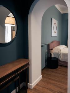 a bedroom with a bed and a mirror at Caffè delle Rose Les Chambres in Verbania