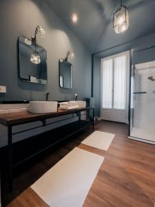 La salle de bains est pourvue d'un lavabo et de deux miroirs. dans l'établissement Caffè delle Rose Les Chambres, à Verbania