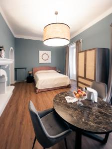 韋爾巴尼亞的住宿－Caffè delle Rose Les Chambres，客厅配有桌子和床。