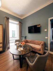 a living room with a couch and a table at Caffè delle Rose Les Chambres in Verbania