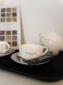 韋爾巴尼亞的住宿－Caffè delle Rose Les Chambres，黑盘上的杯子和碟子