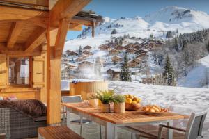 a table in a cabin with a mountain view at Chalet Tolar - OVO Network in Le Grand-Bornand