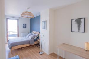 1 dormitorio con cama, escritorio y ventana en MACHOUART le duplex -Parking gratuit Équipée Commodités-, en Aubervilliers