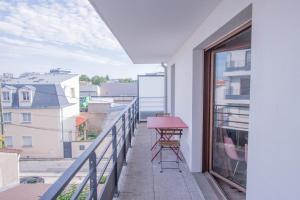 un balcón con una mesa roja y sillas. en MACHOUART le duplex -Parking gratuit Équipée Commodités-, en Aubervilliers
