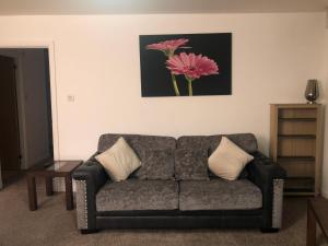 a couch in a living room with a pink flower on the wall at Infiniti properties in Aberdeen