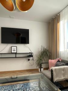 uma sala de estar com uma televisão e uma mesa de café em vidro em Apartament KaMaRo em Słubice