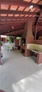 a patio with white chairs and a wooden ceiling at Amoreiras Hotel Pousada in Maresias