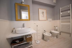 a bathroom with a sink and a toilet and a mirror at Incantevole loft in centro in Perugia