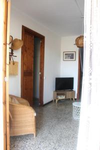 a living room with a couch and a television at Casa Marina in Colònia de Sant Jordi