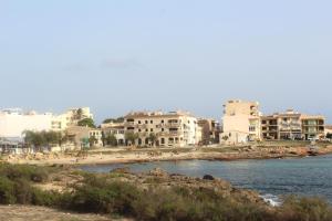 a group of buildings on a beach next to the water at Casa Marina in Colònia de Sant Jordi
