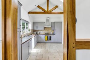 a kitchen with white cabinets and a large window at Silver Stag Properties, 3 BR Dormer Bungalow in Thringstone