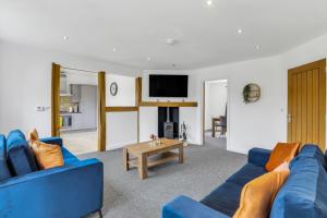 uma sala de estar com um sofá azul e uma mesa em Silver Stag Properties, 3 BR Dormer Bungalow em Thringstone