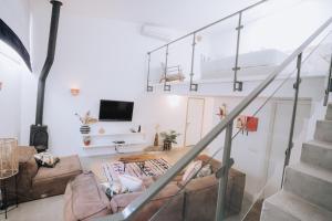 a living room with a couch and a tv at Sol Ramon boutique hotel in Mitzpe Ramon