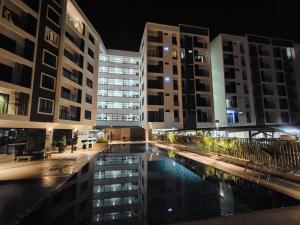 - une piscine au milieu d'un bâtiment la nuit dans l'établissement Gem Suites Minimalist 2BR 4beds Entire Apartment, à Kuching