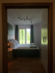 a bedroom with a bed with a window at Luxusferienwohnung mit Sauna - NEUBAU in Ofterschwang
