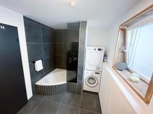 La salle de bains est pourvue d'un lave-linge et d'un lave-linge. dans l'établissement Luxusferienwohnung mit Sauna - NEUBAU, à Ofterschwang