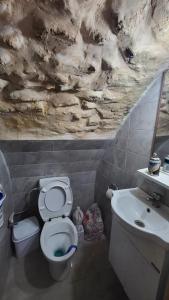 a bathroom with a white toilet and a sink at historic luxury cave in Jerusalem