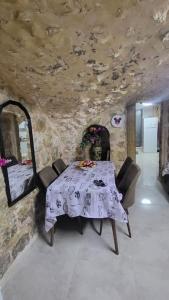 a dining room with a table and a stone wall at historic luxury cave in Jerusalem