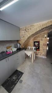 a kitchen with a table and a stone wall at historic luxury cave in Jerusalem