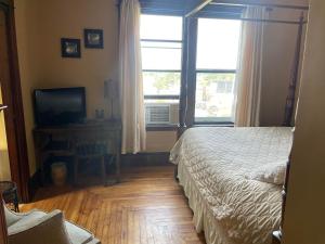 um quarto com uma cama, uma televisão e uma janela em Awakenings Inn em Montague