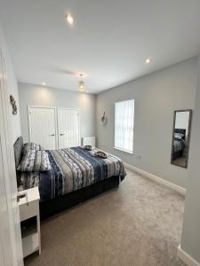 a bedroom with a bed and a mirror at Ocean View Suite - Near Hythe - On Beach Seafront - Private Parking in Dymchurch