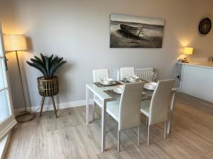 a dining room with a table and chairs and a painting at Ocean View Suite - Near Hythe - On Beach Seafront - Private Parking in Dymchurch