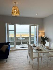 a dining room with a table and a view of the ocean at Ocean View Suite - Near Hythe - On Beach Seafront - Private Parking in Dymchurch