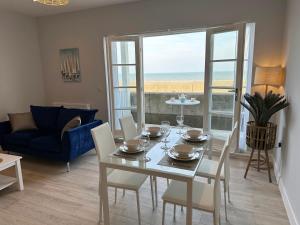 a living room with a table and chairs and a couch at Ocean View Suite - Near Hythe - On Beach Seafront - Private Parking in Dymchurch