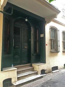 uma porta verde da frente de um edifício com escadas em Kaboom Showroom & Guesthouse em Istambul