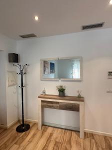 Zimmer mit einem Tisch und einem Spiegel an der Wand in der Unterkunft CAROLINAS SUIT in Alicante