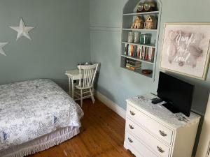 1 dormitorio con cama y vestidor con TV en Awakenings Inn, en Montague