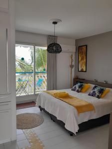 a bedroom with a bed and a large window at Studio COEUR PASSION VUE MER charme et standing in Saint-François