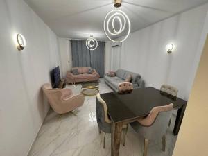 a living room with a table and chairs and a couch at شقة في مدينتي بي 2 جديدة in Madinaty