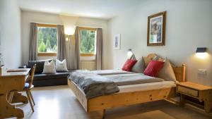 a bedroom with a large bed and a couch at Gletscher-Hotel Morteratsch in Pontresina