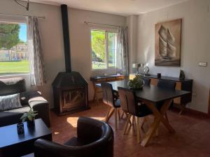 een woonkamer met een tafel en een houtkachel bij Islantilla Golf - Luxury house in Isla Cristina