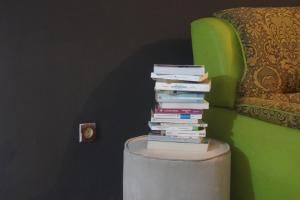 a stack of books sitting on top of a stool at Au cœur de Ouidah 2 in Ouidah