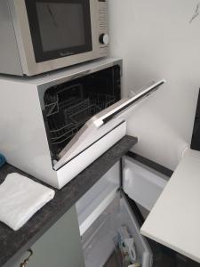 eine offene Mikrowelle auf einem Kühlschrank in der Unterkunft hauts des 2 lions -studio in Joue-les-Tours