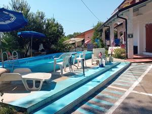 piscina con sedie e ombrellone di Village SOGNO a Massa