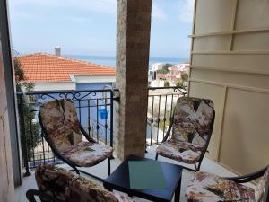 2 sedie e un tavolo sul balcone di Apartments Relax a Utjeha