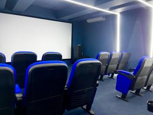 ein leeres Zimmer mit blauen Stühlen und einem weißen Bildschirm in der Unterkunft Downtown Luxury Apt Naco: 2br 2ba in Santo Domingo