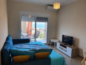 un soggiorno con divano blu e TV di Apartments Relax a Utjeha