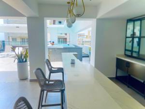 a dining room with chairs and a large white table at Downtown Luxury Apt Naco: 2br 2ba in Santo Domingo