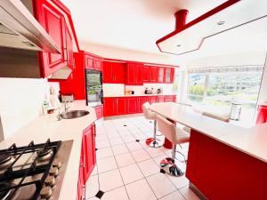 a kitchen with red cabinets and a white tile floor at Hotel Vibes Cape Town Plattekloof in Cape Town