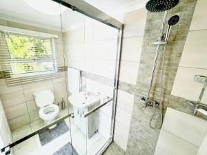 a bathroom with a shower and a toilet and a sink at Hotel Vibes Cape Town Plattekloof in Cape Town