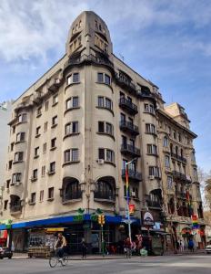 un edificio alto en una calle de la ciudad con gente en bicicleta en Nuevo Hotel Aramaya en Montevideo