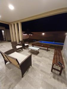 una sala de estar con sillas y mesas y una piscina en Casa del Sol en Salta